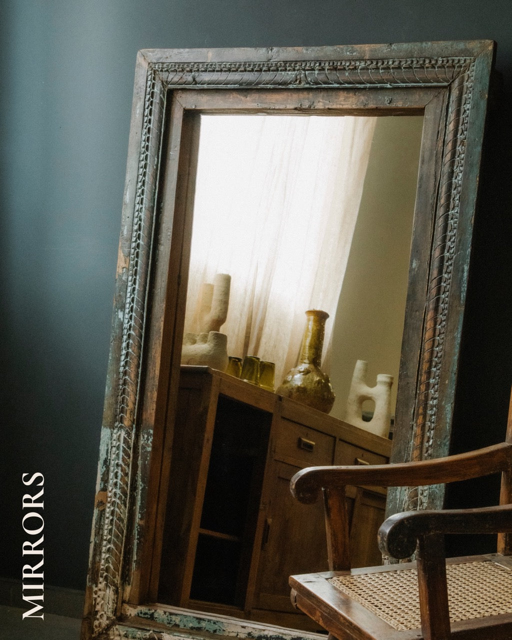 Wooden carved vintage mirror, leaning on a dark wall