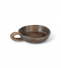 A hand carved wooden bowl with a handle, showing a natural brown patina finish.