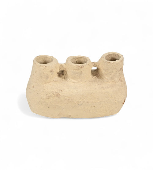 A beige papier mache pot with a sculptural form, featuring multiple openings on the top.