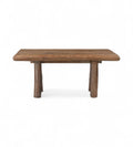A rectangular kitchen dining table made of old solid reclaimed wood with thick cylindrical legs.