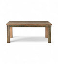 A rectangular kitchen dining table made of reclaimed wood with a rustic patina finish.