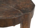 A vintage Indian teak wood side table/ stool with an irregular shape and a dark patina, indicating age and use.