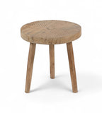 A round reclaimed wooden side table with visible wood grain and unique etching on the surface, supported by three legs.