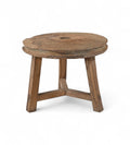 A round, vintage reclaimed wood side table with tripod legs and visible weathered patterns, once used as a pulley wheel for drawing water.