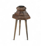 Carved teak candle holders on top of three legs