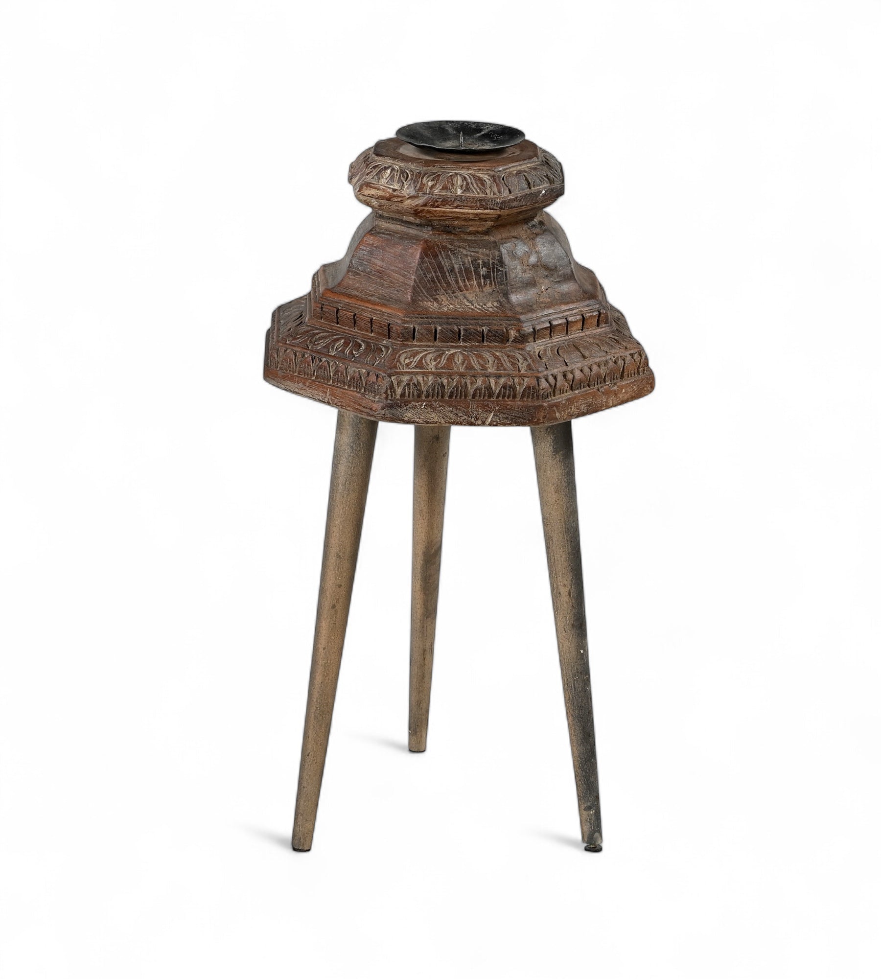 Carved teak candle holders on top of three legs