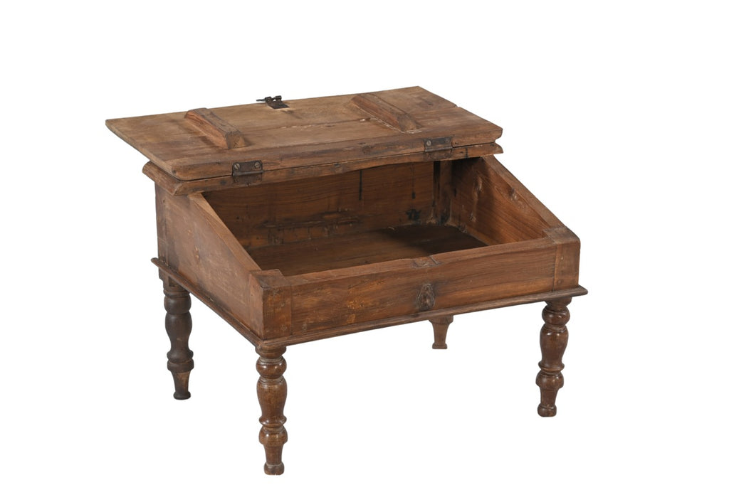 A vintage teak wood desk with a visible wood grain pattern and carved legs, with a closed hinged lid.