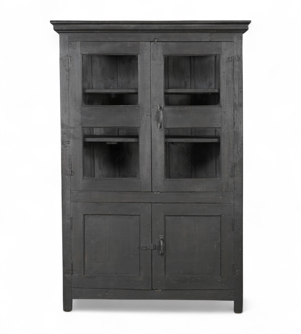 A vintage teak and glass display cabinet with black finish, featuring glass panelled upper doors and teak lower doors with an iron latch.