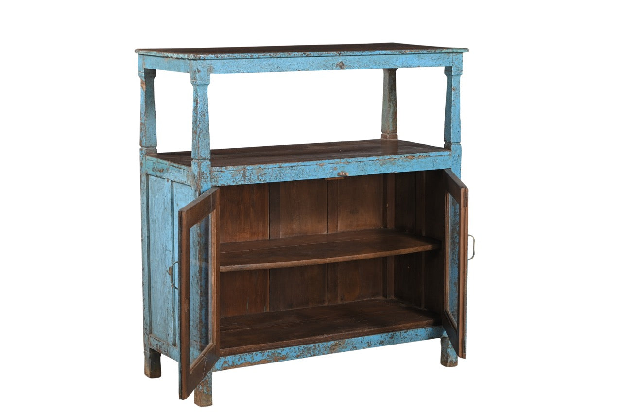 A vintage teak wood and glass cabinet with blue paint and patina, featuring a top shelf and double doors.