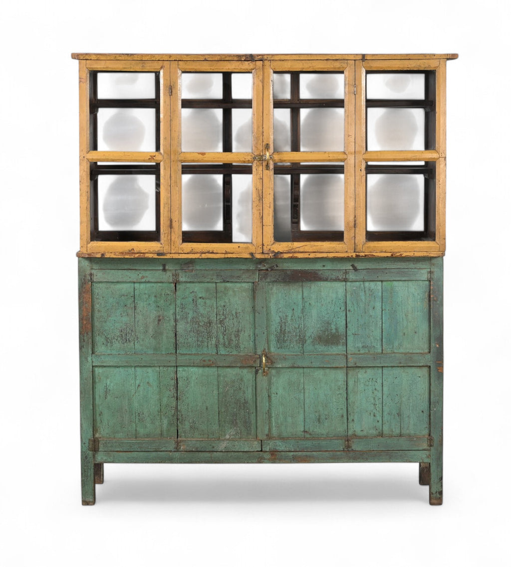 A vintage teak and glass display cabinet with a green patina and wooden upper structure with glass panels.