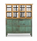 A vintage teak and glass display cabinet with a green patina and wooden upper structure with glass panels.