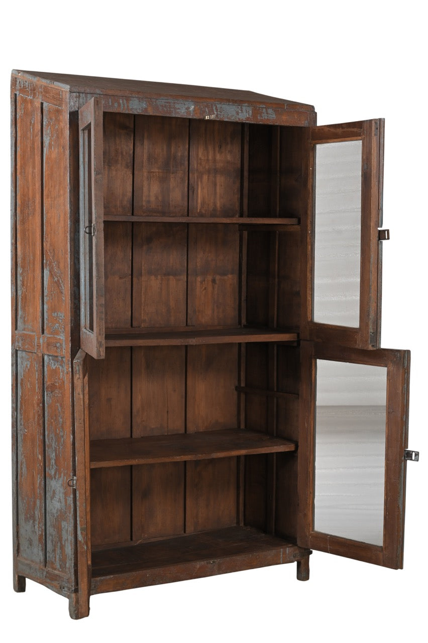 A vintage teak wood glass display cabinet with four glass doors and a visible wood patina of earthy brown and faded indigo.