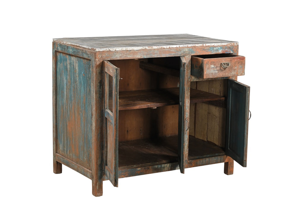 A vintage teak wood cabinet with glass panels on the doors and a painted terracotta red, deep blue, and neutral colours finish.