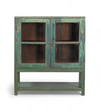 A vintage teak wood glass display cabinet with green paint on the exterior and brown interior, featuring two glass panelled doors with a single shelf.