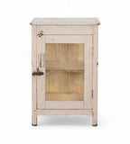 A vintage teak wood side cabinet in a white finish with a glass panel on the door, and one internal shelf.