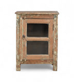 A vintage teak wood side cabinet with a weathered frame, a glass door, and a metal pull ring