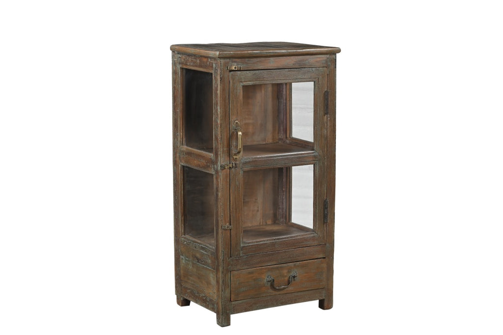 A vintage teak wood side cabinet with a glass display door and a drawer, showing a brown and green patina.