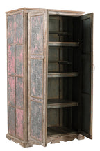 A vintage teak wood wardrobe with iron panels, featuring a carved base and an aged patina finish in soft pink and faded grey.