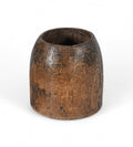 A vintage teak wood pot with a patina finish, hand-carved in India, with visible textural details on the surface.