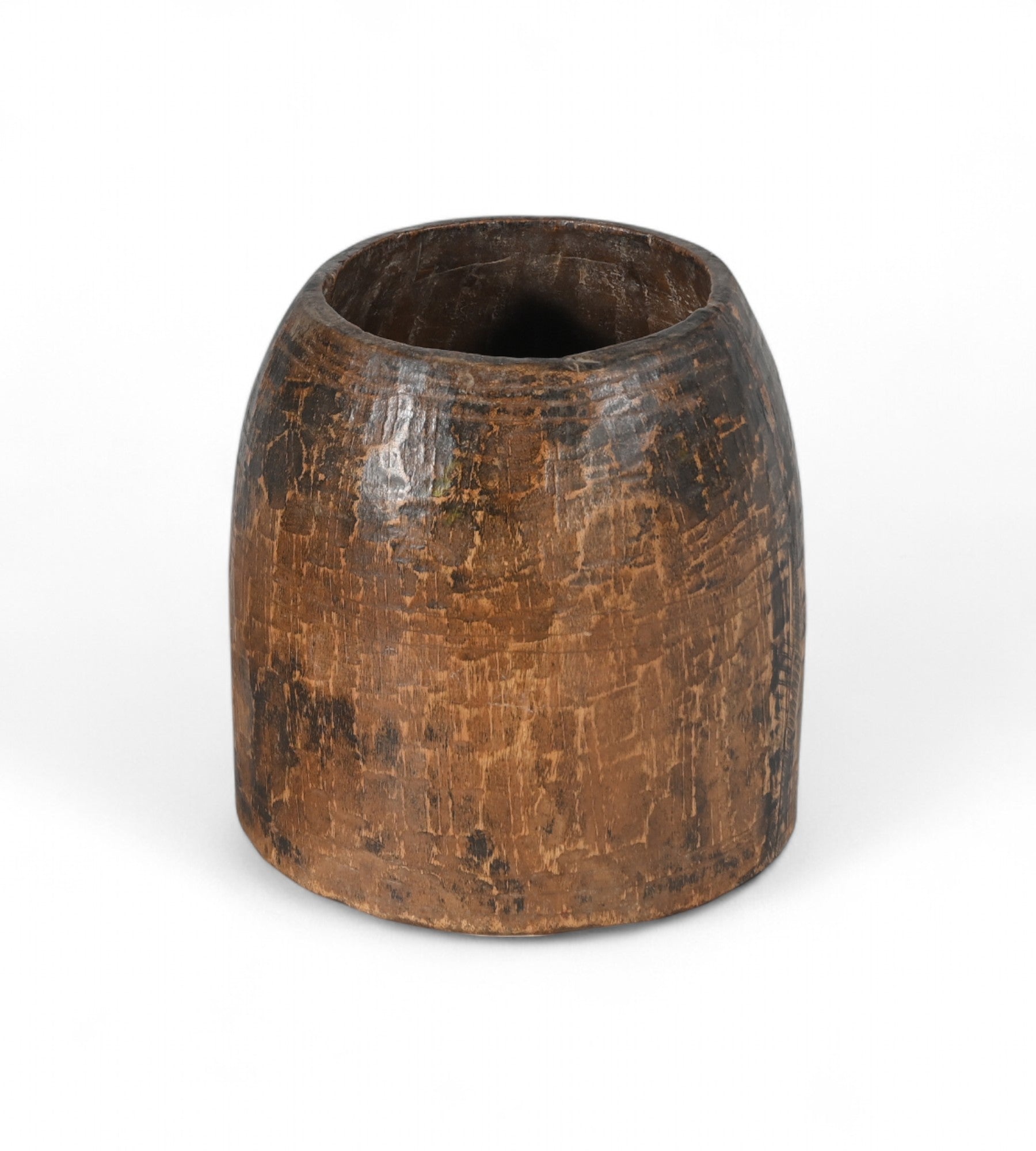 A vintage teak wood pot with a patina finish, hand-carved in India, with visible textural details on the surface.