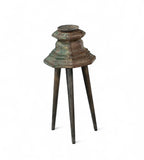 Carved teak candle holders on top of three legs