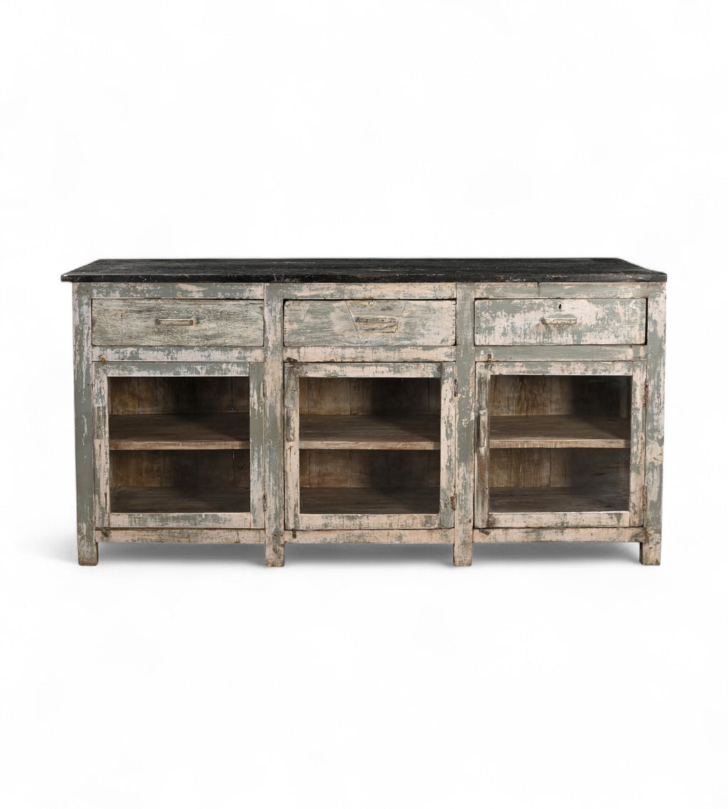 A vintage teak wood kitchen cabinet / kitchen island with glass panels on the cupboards, featuring a dark wood tabletop and an aged green and white patina finish.