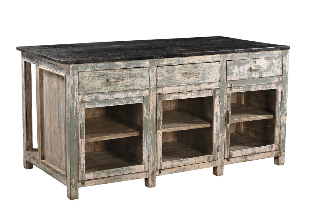 A vintage teak wood kitchen cabinet / kitchen island with glass panels on the cupboards, featuring a dark wood tabletop and an aged green and white patina finish.