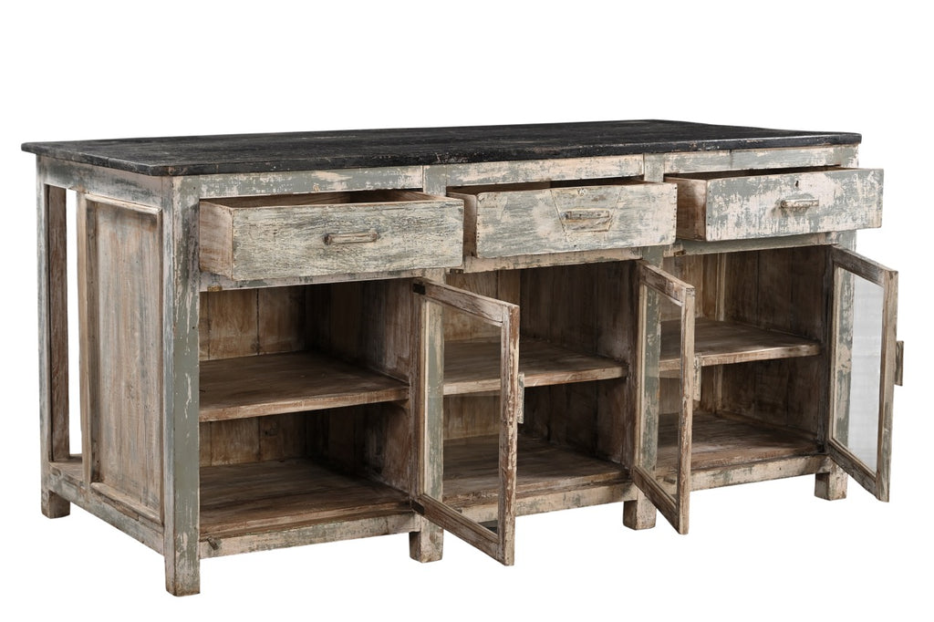 A vintage teak wood kitchen cabinet / kitchen island with glass panels on the cupboards, featuring a dark wood tabletop and an aged green and white patina finish.