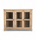 A vintage teak and recycled wood glass cabinet with a warm honey tone finish and three glass doors.