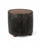 A cylindrical vintage side table made of iron with a teak wood top, featuring ring handles and a worn black finish.