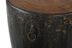 A cylindrical vintage side table made of iron with a teak wood top, featuring ring handles and a worn black finish.