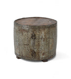 A cylindrical vintage side table made of aged iron with a teak wood top, featuring ring handles and a weathered finish.