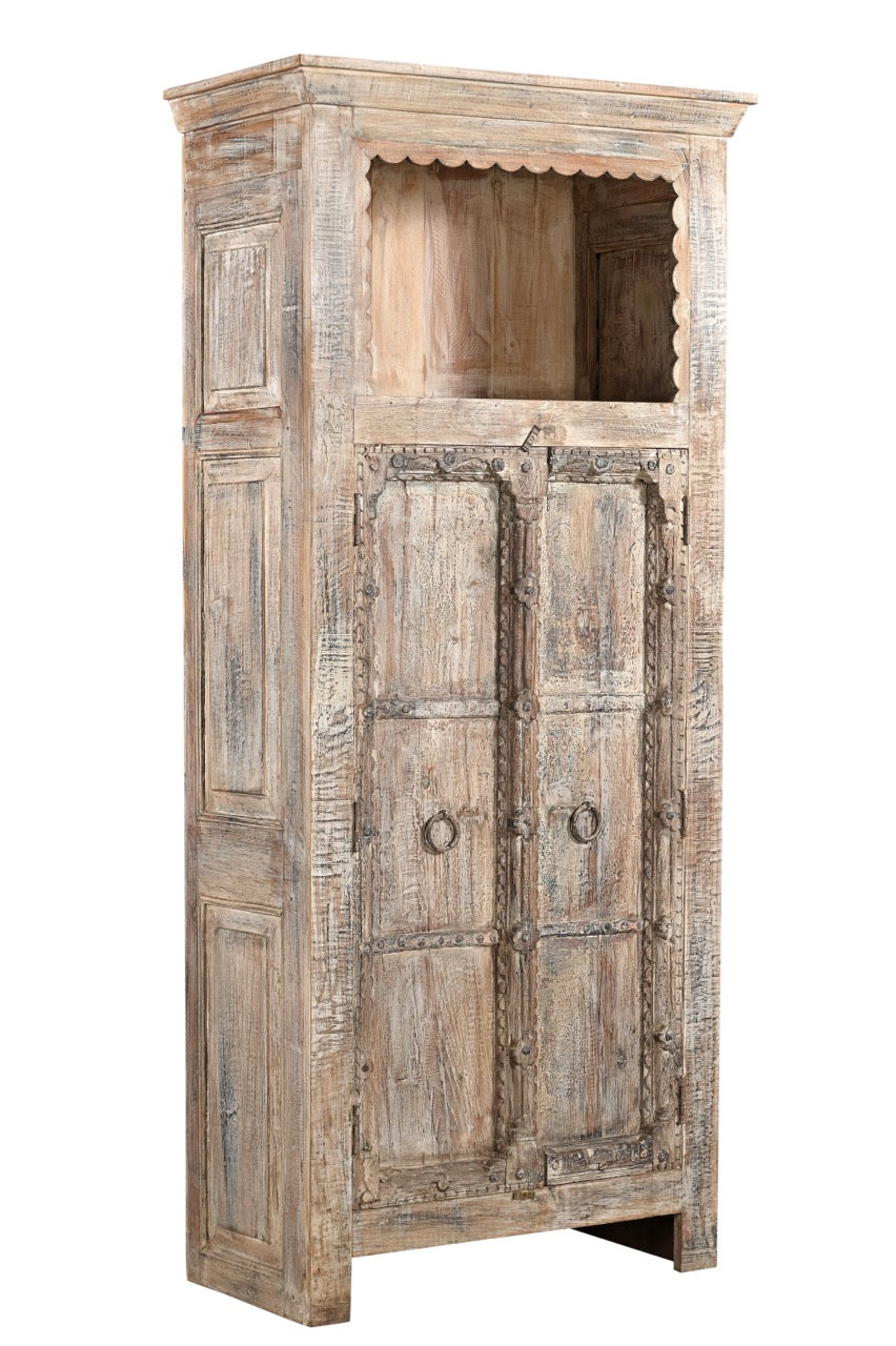 A vintage teak and recycled wood wardrobe with hand-carved details and a lime/multi-coloured patina. It features an upper open section with a scalloped wooden arch and two doors with a visible handle.