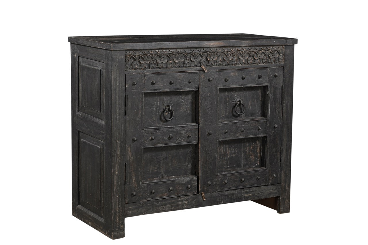 A vintage teak wood side cabinet with iron accents and a carved floral frieze, finished in black.