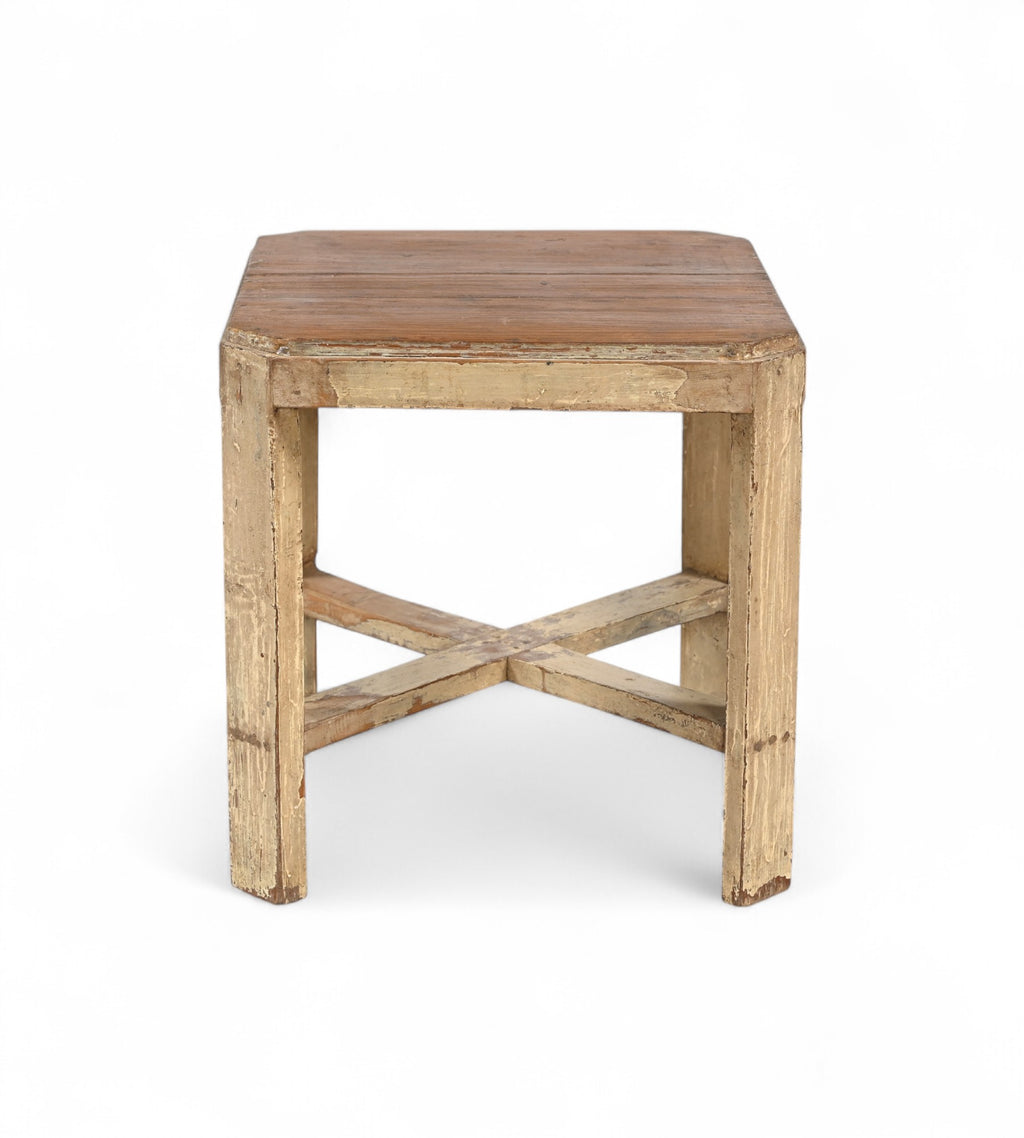 A vintage teak wood side table with off white painted legs and a cross brace detail at the bottom.
