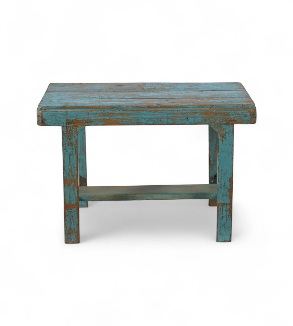 A rectangular vintage teak wood side table with a faded blue finish.