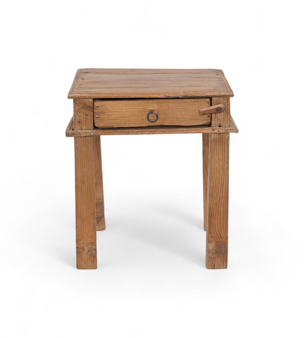 A tiny vintage teak wood side table with a visible drawer and a metal pull ring,