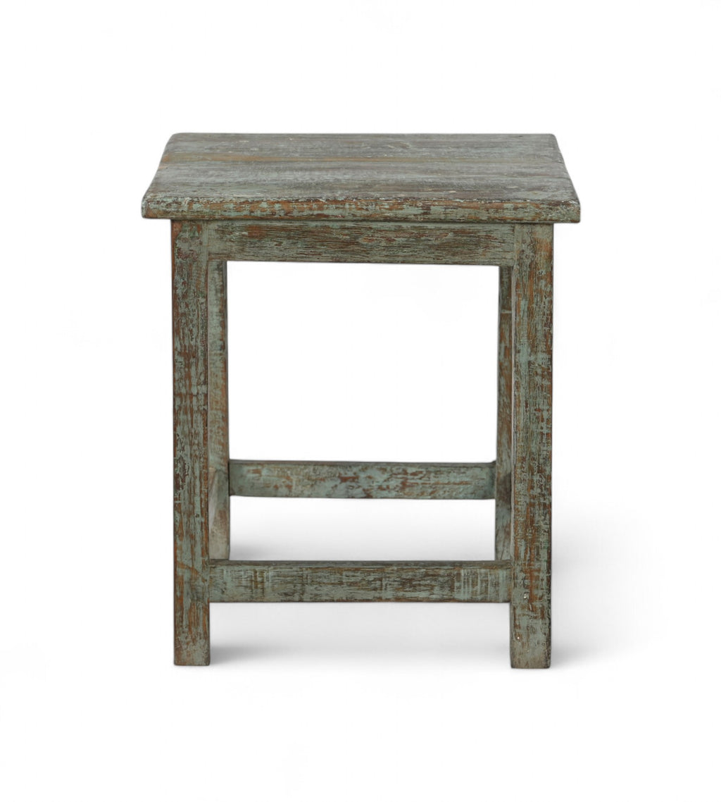 A vintage teak wood side table with a weathered green finish.
