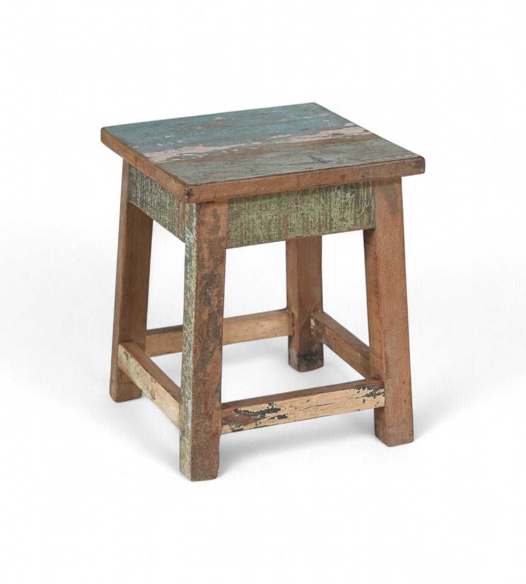 A vintage recycled wood side table with a multicoloured tabletop and brown legs.