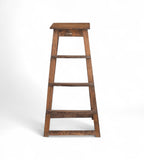 A tall vintage teak wood bar stool with a natural patina and warm tones, featuring visible wood grain and imperfections.
