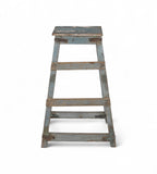 A vintage teak wood bar stool with a faded soft blue patina and iron brackets.