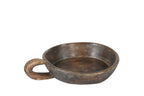 A hand carved wooden bowl with a handle, showing a natural brown patina finish.