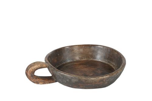 A hand carved wooden bowl with a handle, showing a natural brown patina finish.