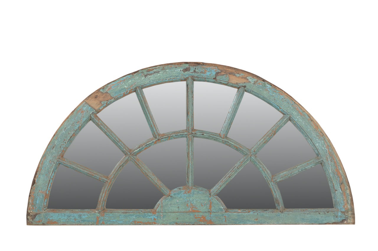 Arched mirror with a distressed turquoise frame on a white background
