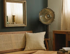 Vintage-style room with a mirror, lamp, and wooden bench.
