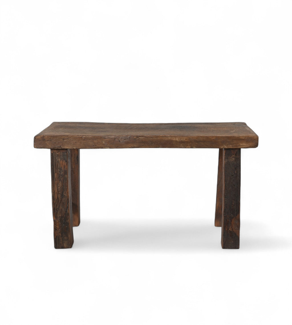 A vintage reclaimed wood bench with a rectangular seat and wooden legs.