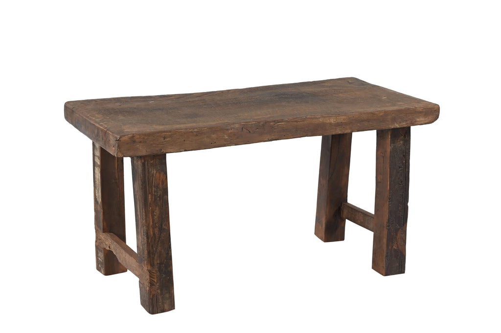 A vintage reclaimed wood bench with a rectangular seat and wooden legs.