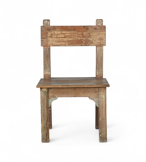 A wooden chair with a patina finish, featuring hints of green and yellow paint, with a simple backrest and seat design.