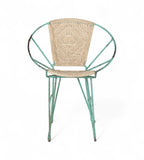 A vintage chair with a green iron frame and natural rope seat and backrest.