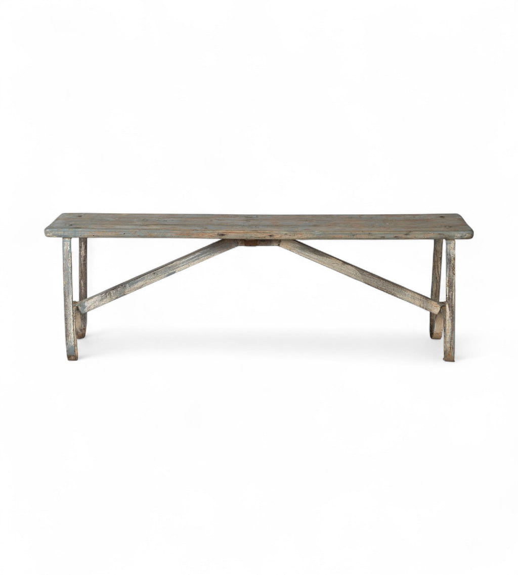 A vintage teak wood and iron bench with a weathered finish and curved leg design.